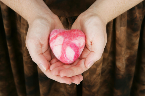 A woman's hands holding a small felted heart (made by me).