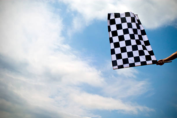 Checkered flag waving under a blue sky stock photo