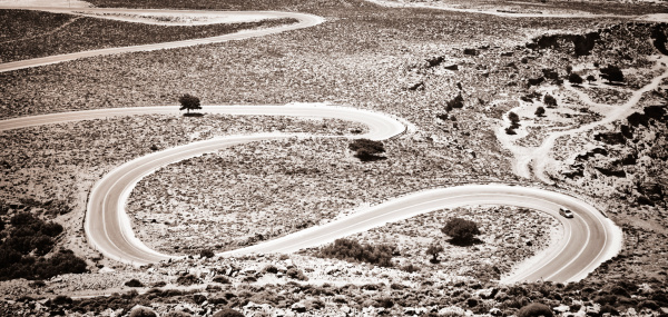 Small car on curvy road. Toned image.