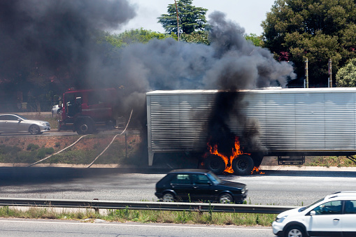 Truck wheels on Fire on the highway with the fire brigade about to extinguish the fire.
