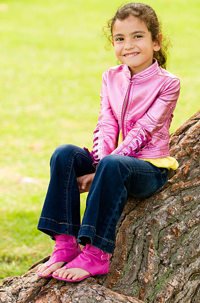 Smiling Girl on Tree Trunk stock photo