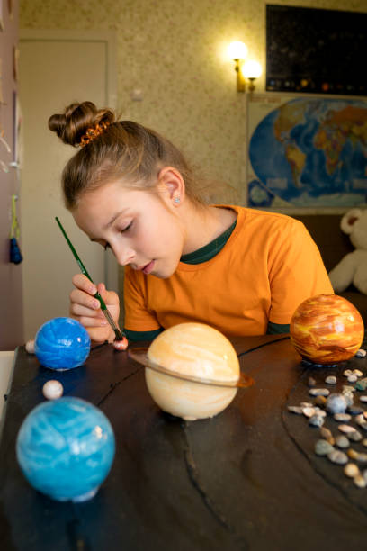 istock Young Astronomer Painting Celestial Orbs 1749683390