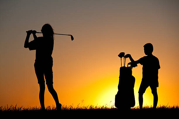 istock Junior Girl Golfing Silhouette with Young Caddie 174968358