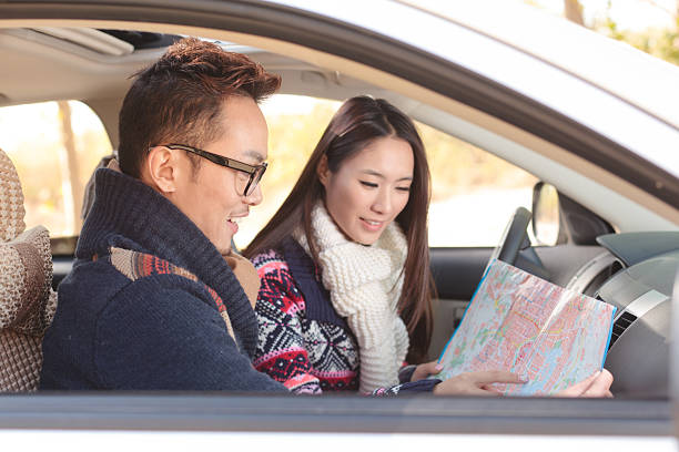 istock Young couple in car with map 174968505