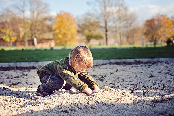 Little boy digging at the playground stock photo