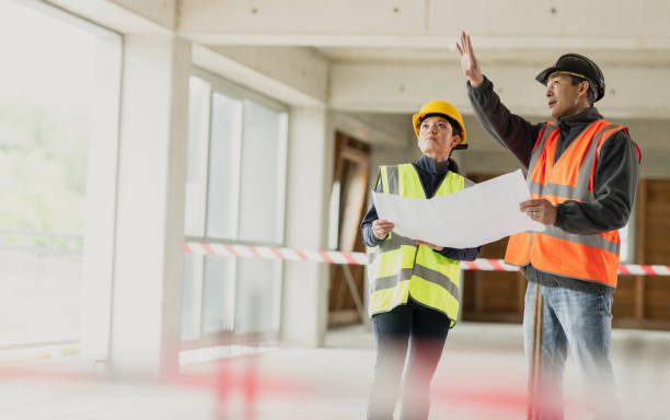 istock Construction foreman explaining details to investor while they hold a blueprint 1749695010