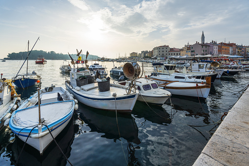 Small boats in the crowded harbor in Rovinj at sunset