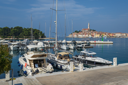 Sail boats anchored in marina in Rovinj, old townscape in the distance