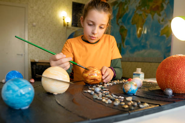 istock Young Astronomer Painting Celestial Orbs 1749705365