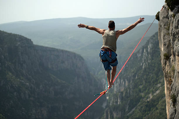 homem a andar um slackline sobre verdon gargantas, frança - recreational sports imagens e fotografias de stock