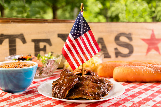 cibo: barbecue costolette, stufati, insalata di patate e una bandiera americana. - texas state flag foto e immagini stock