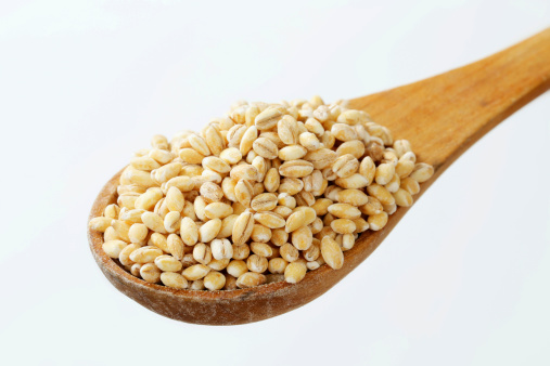 pile of peeled barley on a deep wooden spoon
