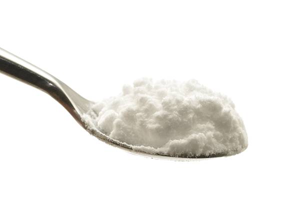 Bicarbonate of soda on a spoon "Bicarbonate of soda on a spoon, isolated on a white background." teaspoon stock pictures, royalty-free photos & images
