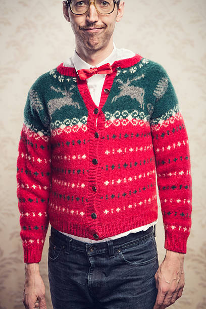 Christmas Sweater Nerd A man in a knit reindeer Christmas cardigan button up sweater, complete with matching red bow tie and a classy mustache.  Damask style vintage wall paper in the background.  Vertical. vintage nerd with reindeer sweater stock pictures, royalty-free photos & images