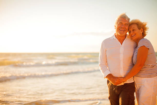 istock Senior couple walking on the beach 174973308