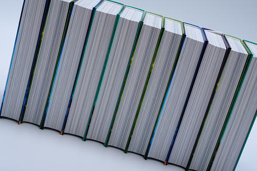 A neatly arranged stack of hardcover books, a collection closeup