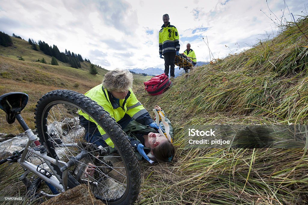 Soccorritore partecipare alla mountain bike vittime di incidenti - Foto stock royalty-free di Collare cervicale