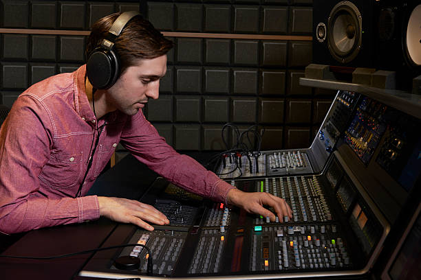 Sound engineer working at mixing desk in recording studio Working with digital recording equipment sound technician stock pictures, royalty-free photos & images