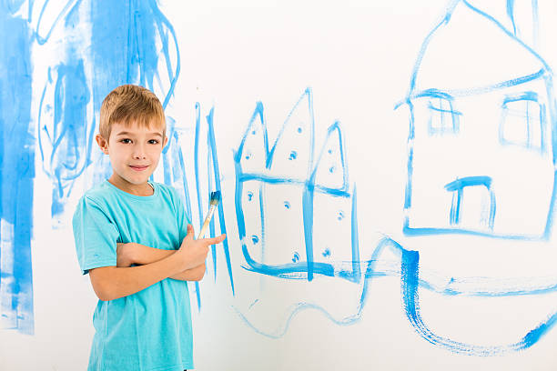 istock Boy painted a house on the wall 174974558