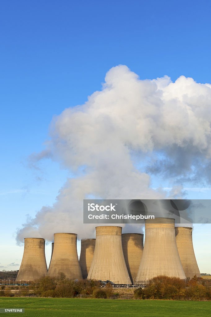 Cooling Towers, Power Station Large collection of cooling towers emitting steam against a clear blue sky. Ratcliffe Upon Soar Stock Photo
