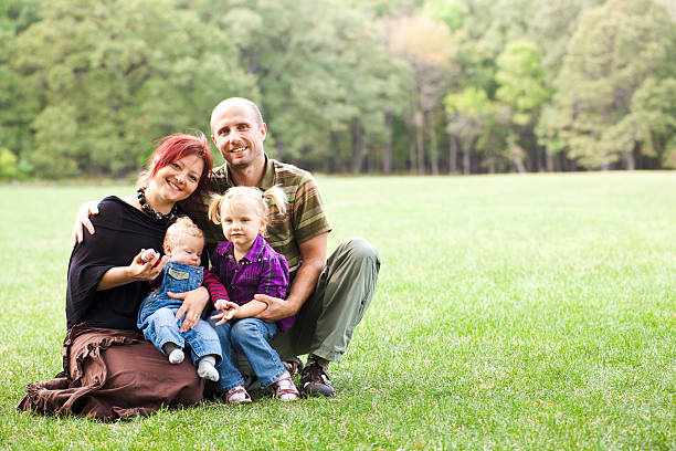 istock Young couple with kids in the park 174975359