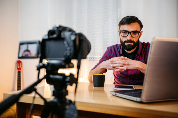 istock Young Male Writer Filming A Vlog On Writing At Home 1749756624
