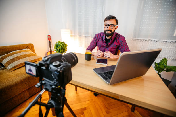 istock Young Male Writer Filming A Vlog On Writing At Home 1749757793