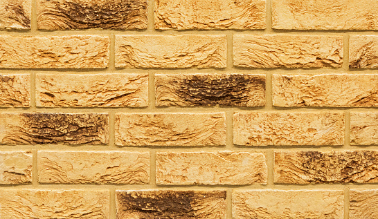 Old beige color stone material brick wall pattern background