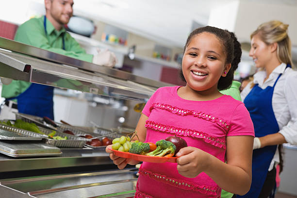 istock Happy elementary school student choosing healthy food in lunch line 174976187