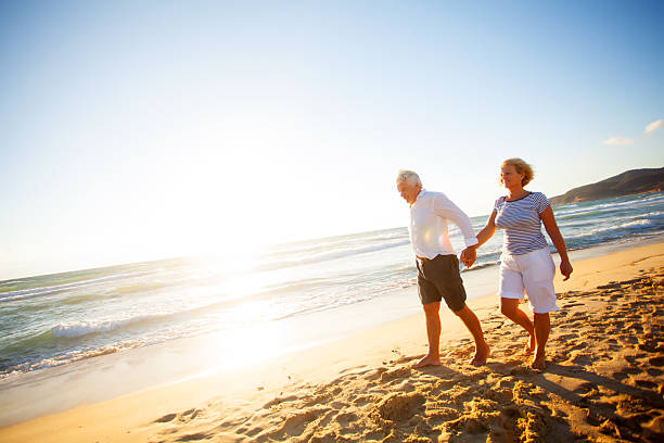 istock Senior couple walking on the beach 174976409