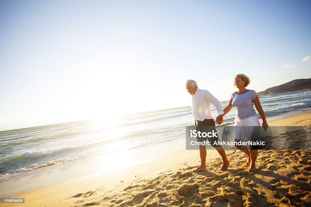 Senior couple walking on the beach 60-69 Years Stock Photo