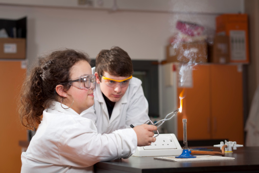 Two science students experiment burning magnesium ribbon in a science laboratory. Adobe RGB 1998 profile.