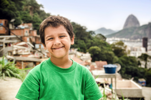 Smiling Kid with the Santa Marta Favela and Sugar Loaf on the brackground.Rio de Janeiro