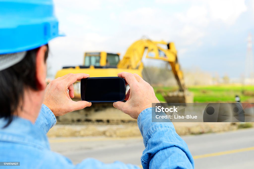 Con telefono intelligente di ingegnere in Cantiere di costruzione - Foto stock royalty-free di Cantiere di costruzione