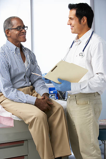 istock Doctor In Surgery With Male Patient Reading Notes 174977395