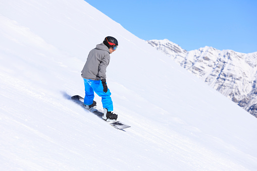 Snowboarding.  Young man snowboarder on the mountain ski slope.