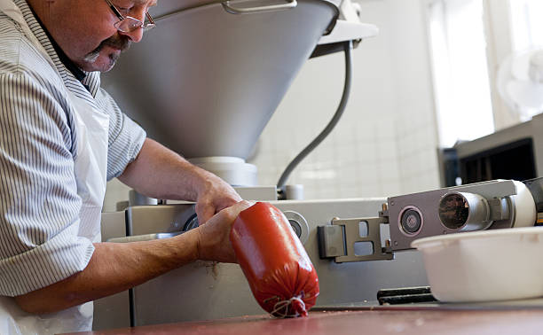 istock butcher filling sausages with Fleischk 174977662