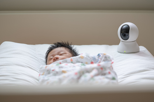 baby monitor at home while sleeping for security in modern family on warm bed blanket