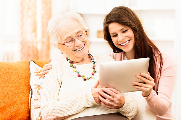 istock Granddaughter teaching her grandmother to use a tablet 174978466