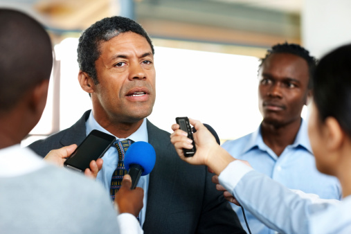 Mature African business man answering to journalists during a press conference