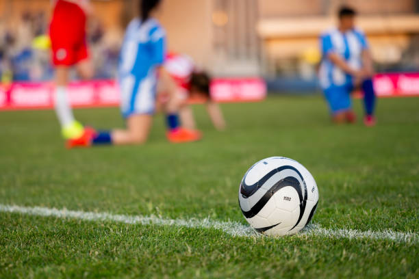 istock Soccer ball on white halfway line on field 1749790193