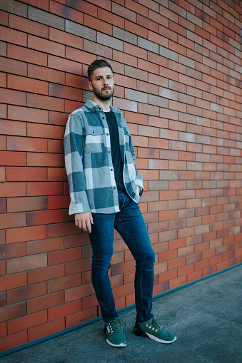 Fashion-forward and confident, this city street portrait highlights a fashionable bearded male. Fashionable Bearded Male looking at camera City Street Portrait