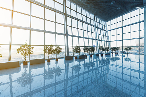 Empty airport terminal waiting area with green chairs