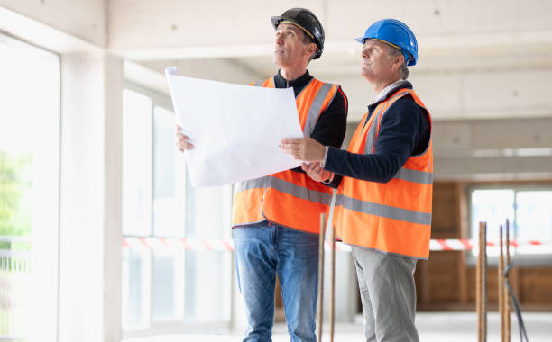 istock Construction foreman explaining details to investor while they hold a blueprint 1749792389