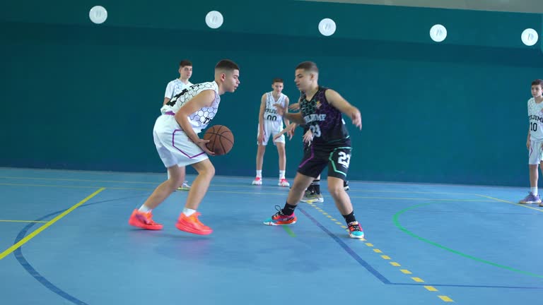 Teens playing basketball indoors