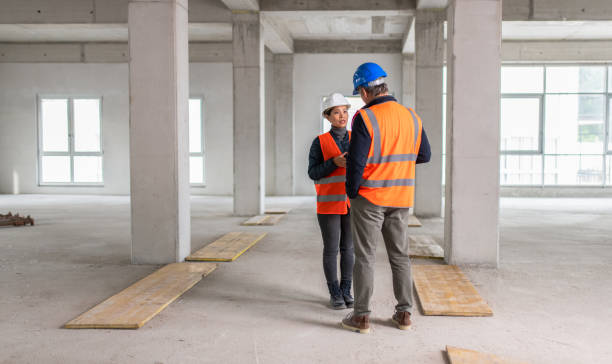 istock Construction foreman explaining details to investor while they hold a blueprint 1749800279
