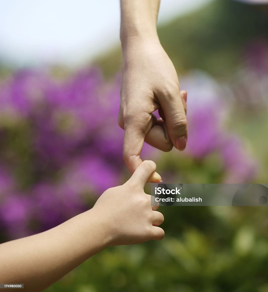 Togetherness A child's hand holding mother's hand. A Helping Hand Stock Photo