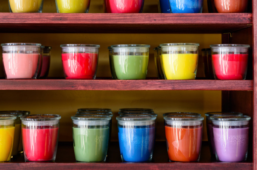 Vibrant colors from wax candles in glass jars on wooden shelves.  Captured as a 14-bit Raw file. Edited in 16-bit ProPhoto RGB color space.