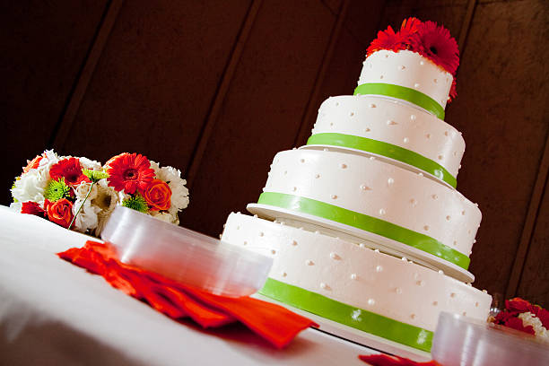 istock White Wedding four tier dot Cake, Gerber daisy red flowers 174980284