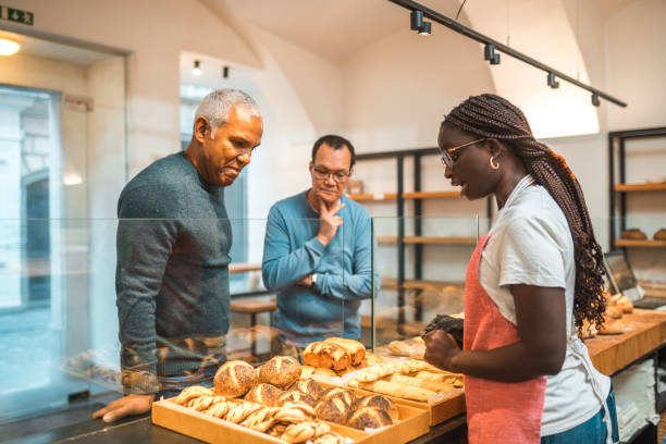istock Cheerful Black Female Serving Customers In An Artisan Bakery 1749808791